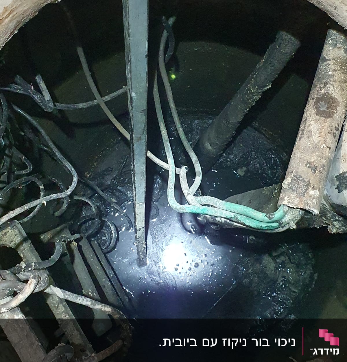 פתח ביוב עם צינורות וחוטים